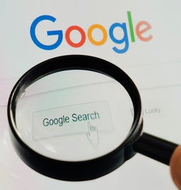 Magnifying glass hovering over the Google homepage search bar