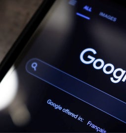 Closeup of Google search on a phone in dark mode