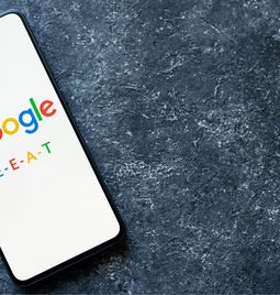 A phone with the google logo on the screen and text reading 