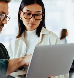 A man and woman starting at a laptop together