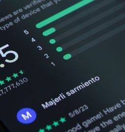 a mobile displaying a rating of 4.5 stars from 27,777 reviews and a user comment about performance.