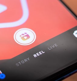 Close-up of a smartphone screen displaying a video app interface with options for 'Story,' 'Reel,' and 'Live' highlighted.