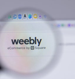 Weebly logo on a desktop visible under a magnifying glass