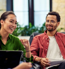 Colleagues sitting around a sofa talking