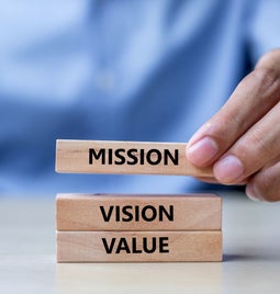 man placing jenga block labelled 