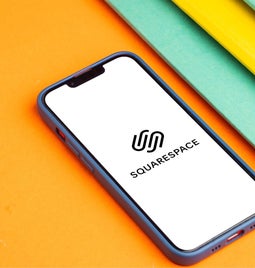 Screenshot of a phone with Squarespace logo on the screen, on top of an orange background