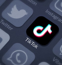 TikTok app logo highlighted with greyed out social media icons around it