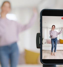 phone on tripod filming woman dancing