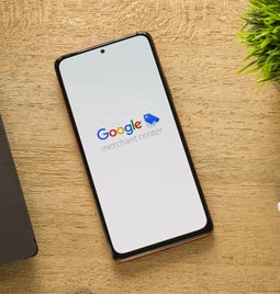 phone on brown table with merchant center logo on