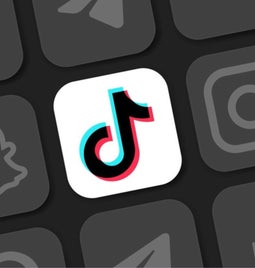 Different social media logos in black and white with the TikTok logo in colour at the centre