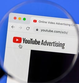youtube advertising page on laptop screen covered by magnifying glass